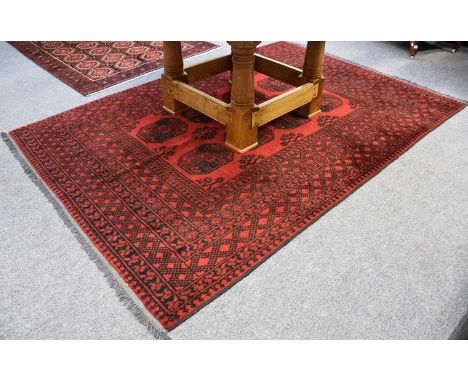 Afghan Turkmen Rug, the light claret field with eight elephant foot güls enclosed by multiple borders, 242cm by 166cm, togeth
