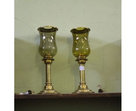 A BOX CONTAINING A PAIR OF EARLY 20TH CENTURY BRASS BASED CANDLESTICK with storm glass shades