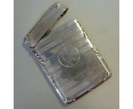 A silver card case, having a hinged cap, decorated with engine turned and foliate cast designs  J&S  Chester 1911