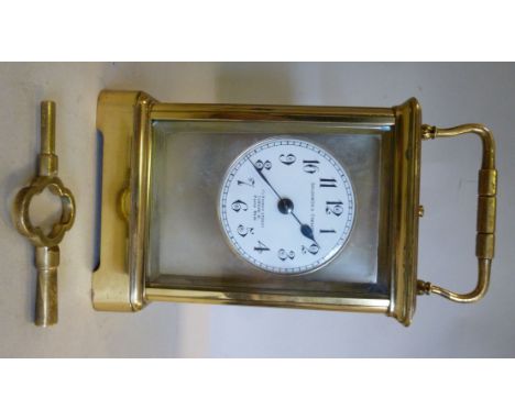 A mid 20thC French lacquered brass cased carriage clock, having bevelled glass panels and a folding top handle, on a plinth; 