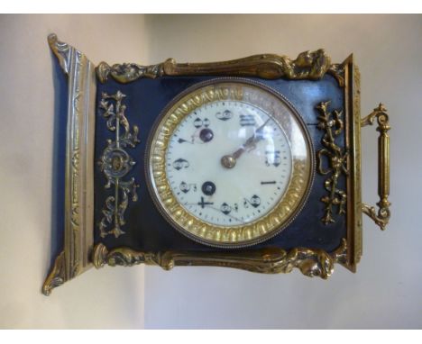 An early 20thC Continental decoratively cast brass and black lacquered wooden cased mantel clock, having straight sides, a fo