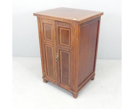 An early 20th century mahogany and satinwood banded music cabinet, with two panelled doors and shelf fitted interior. 52x83x4