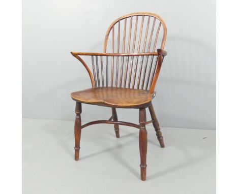 An antique elm-seated comb-back Windsor elbow chair with crinoline stretcher. Overall 58x97x50cm, seat 40x45x36cm.repaired sp