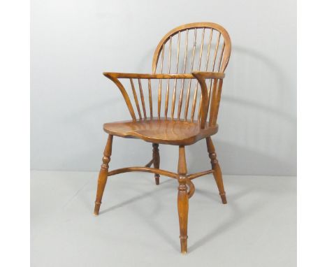 An elm-seated comb-back Windsor elbow chair, with crinoline stretcher.One spindle broken to back and covered in electrical ta