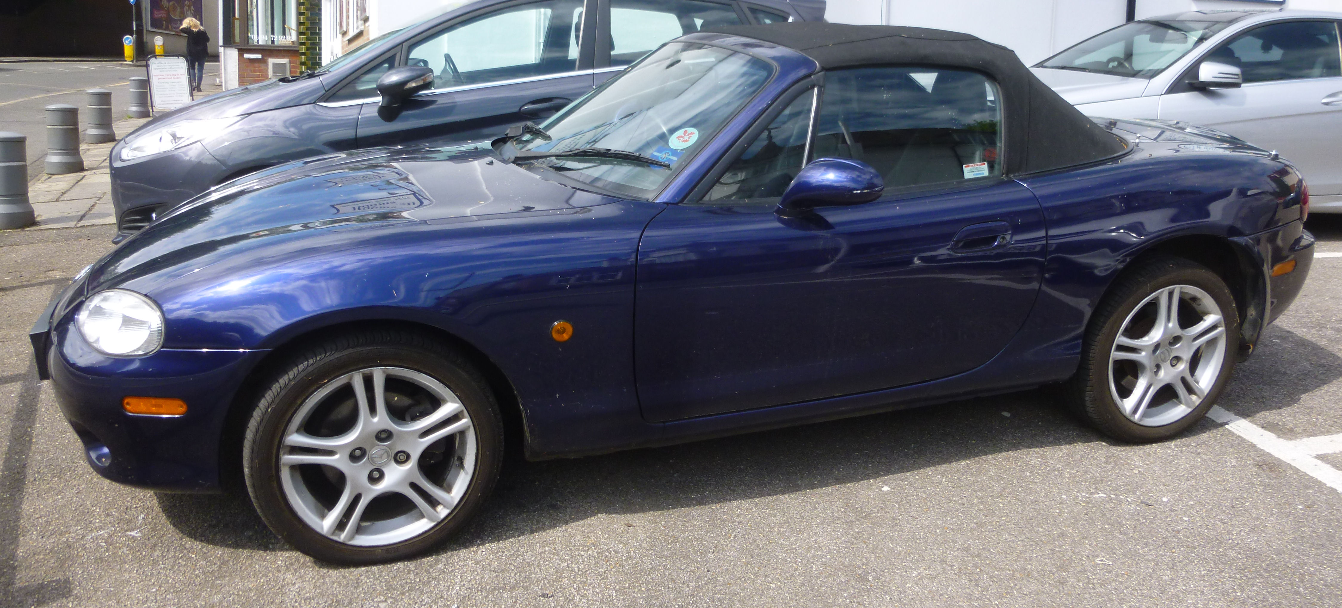 A 2004 Mazda MX-5 two door convertible in dark blue livery ...