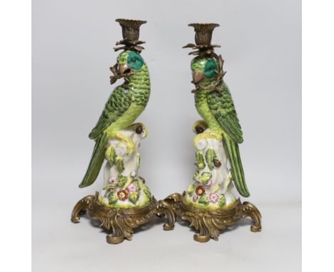 A pair of modern gilt metal mounted ceramic parrot candlesticks, 36cm
