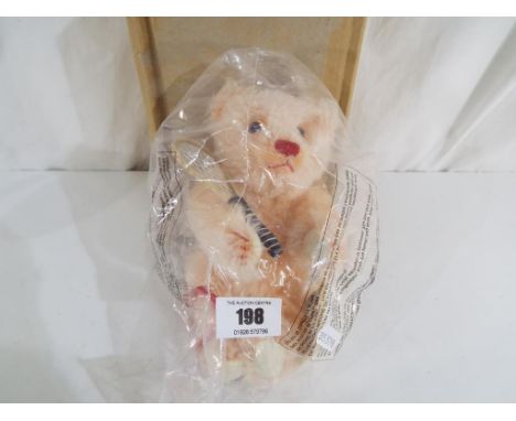 Steiff - a mohair Steiff teddy bear girl tennis player with button, original tags, tennis racket and bag, sealed in original 