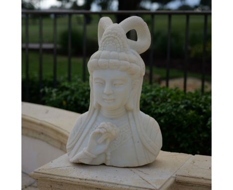 This intricately hand-carved stone bust depicts Guan Yin, the Buddhist bodhisattva of compassion. Known for her serene expres