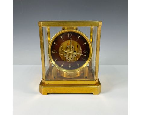This exquisite Le Coultre Atmos clock is housed in a rectangular gold-tone metal case, with clear glass panels on all sides t