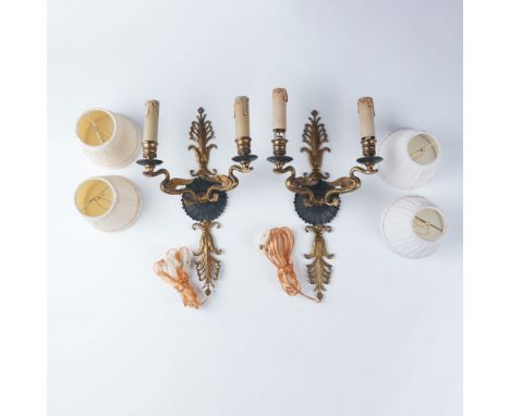 A striking pair of brass wall sconce light fixtures featuring an elegant bird motif. The sconces display a classic design for