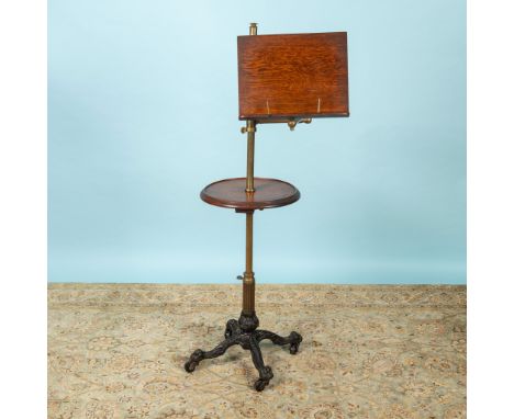 Wooden stand with round center table, adjustable neck and book stand. Stand is set on black cast iron claw foot rolling base.