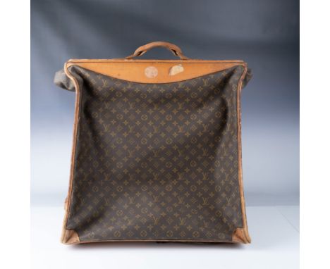 This vintage Louis Vuitton garment bag showcases the iconic brown monogram canvas complemented by equestrian leather trims an