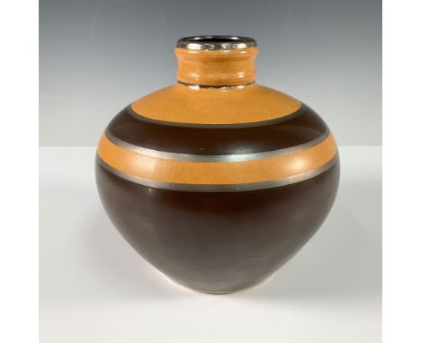 An exquisite example of Art Deco ceramic artistry, features a striking geometric design in warm earth tones of orange and bro