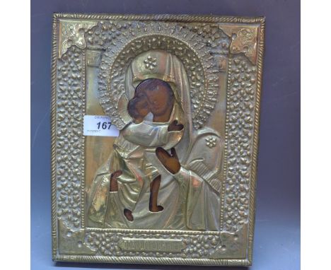 A brass Russian icon having tempera on wood panel beneath. Half length portrait of the Mother of God with Christ in her right
