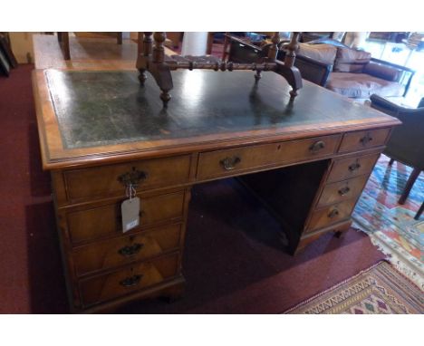 A Georgian style walnut pedestal desk having an arrangement of nine drawers, raised on carved bracket feet. H-77cm W-153cm D-