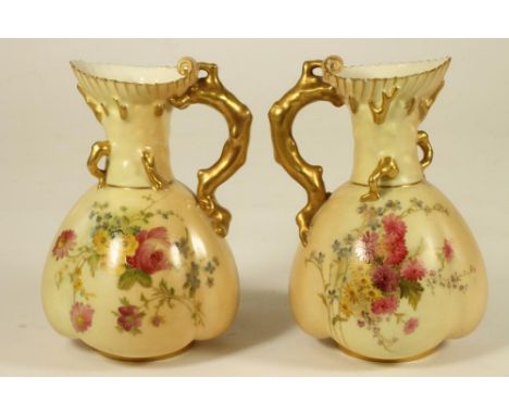 A MATCHED PAIR OF ROYAL WORCESTER CHINA JUGS, 1903/10, of lobed oval form with flared rims and coral twig handles, painted in