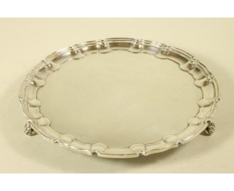 A LATE VICTORIAN SMALL SILVER SALVER, maker Wm. Haseler, London 1899, of shaped circular form with pie-crust rim raised upon 