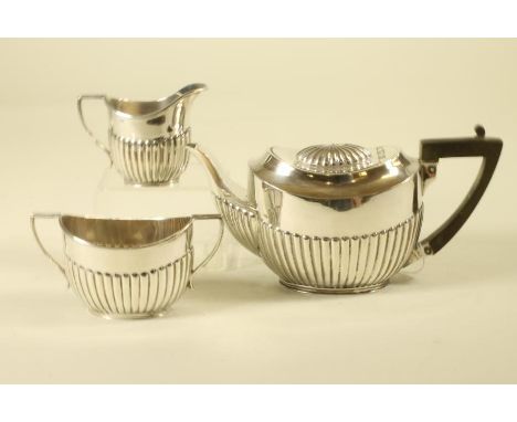 A BACHELOR'S EDWARDIAN SCOTTISH SILVER THREE PIECE TEA SERVICE, makers Hamilton & Inches, Edinburgh 1901, of semi fluted oval