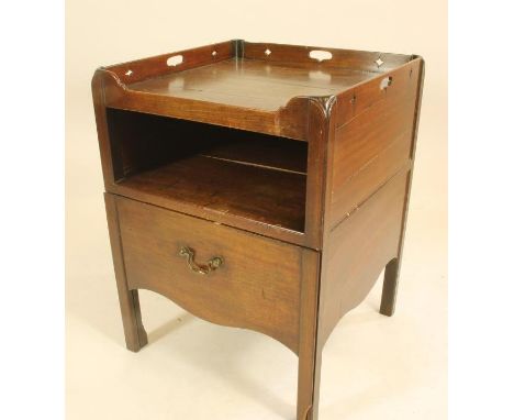 A GEORGIAN MAHOGANY BEDSIDE CABINET, the tray top with pierced loop handles, open shelf below over pull out base having brass