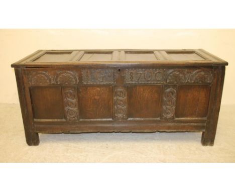 AN OAK PANELLED COFFER, c.1700, with moulded edged and hinged four panel lid, similar fascia with lunette carved frieze inscr