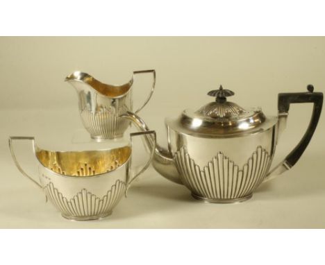 A COMPOSITE EDWARDIAN SILVER THREE PIECE TEA SERVICE, makers Deakin & Deakin, Sheffield 1902 and 1903 (milk jug), of semi flu