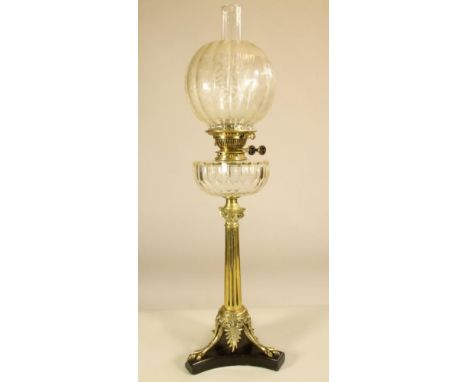 A VICTORIAN BRASS OIL LAMP BASE, the Ionic column raised on three trifurcated supports terminating in claw feet and tied by n