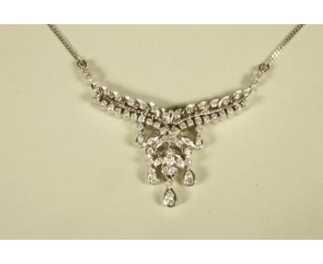 A DIAMOND NECKLACE, the fixed leafy branch pendant with husks and three drop diamonds on a 9ct white gold chain necklace