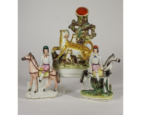 A STAFFORDSHIRE FLATBACK SPILL VASE, c.1850, of a leopard and her two cubs against a tree trunk vase, on a gilt lined oval ba
