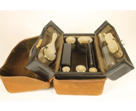 A GENTLEMAN'S SILVER TRAVELLING DRESSING CASE, the grained leather Gladstone type bag stamped "GJW", and containing six vario