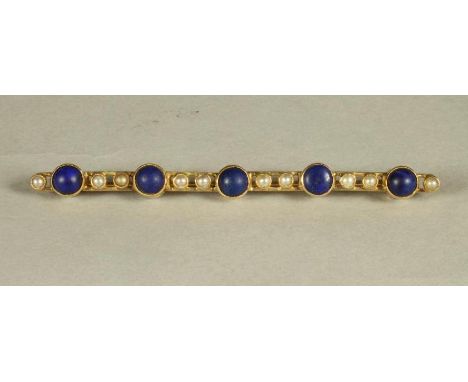 A LATE VICTORIAN BROOCH, the open bars centred by five open back collet set polished lapis lazuli each with two split seed pe