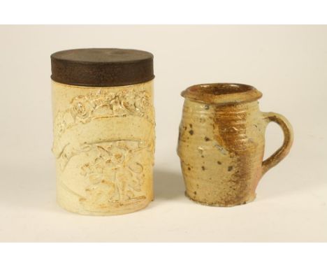 A STONEWARE MUG, possibly 16th century, of bombe cylindrical form in a partial glaze and with applied slightly ribbed drawn h