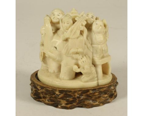 A JAPANESE ONE PIECE IVORY FIGURE GROUP, early 20th century, carved as a group of figures playing musical instruments, holdin