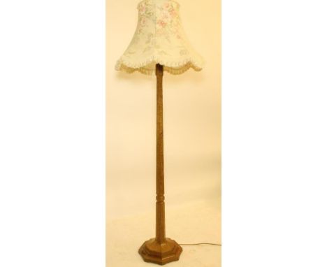 AN ADZED OAK STANDARD LAMP BY ROBERT THOMPSON, the knopped faceted and tapering stem raised on stepped octagonal base with ca