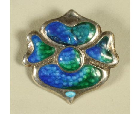 AN EDWARDIAN ARTS AND CRAFTS SILVER AND ENAMEL BROOCH, in the form of a stylised rose with blue shading to green guilloche en