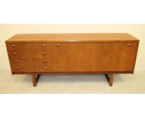 A TEAK SIDEBOARD, c.1960's, European, of low long rectangular form, the top with exposed dovetails on either side, long fall 