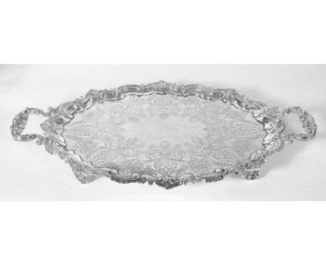 AN EDWARDIAN SILVER TWO HANDLED TEA TRAY, makers Barker Brothers, Chester 1909, of shaped oval form, the pie crust rim with g