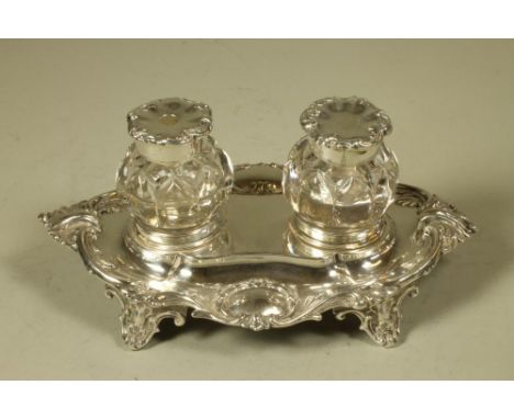 AN EARLY VICTORIAN SILVER INKSTAND, maker Henry Wilkinson & Co., Sheffield 1851, of lobed oval form raised upon four knurl fe