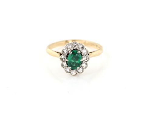 Vintage cluster ring, centrally set with an oval cut green synthetic spinel,  within a round cut white sapphires border, moun