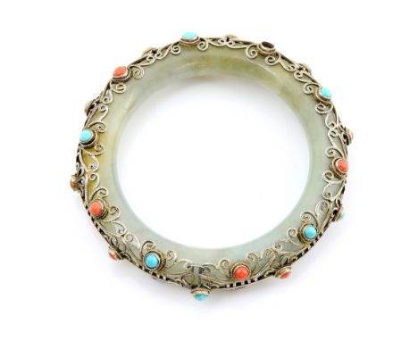 A jade bangle overlaid with white metal filigree decoration set with coral and turquoise cabochons   .     CONDITIONone coral