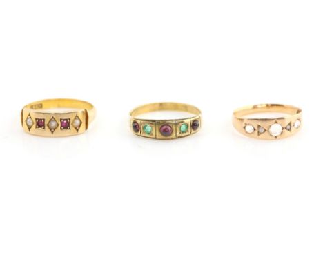 Three Victorian band rings, one set with emerald and cabochon garnets, another with moonstone and white sapphire and a ruby a