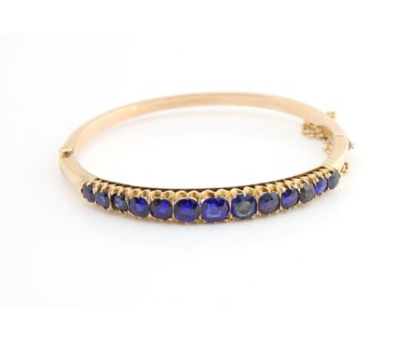 UPDATED DESCRIPTION, the  stones in this bracelet are garnet topped doublets. Victorian hinged gold  bangle set with a line o
