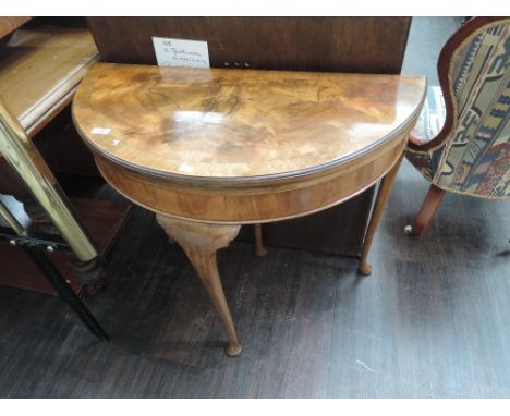 A mid 20th century walnut demi lune card table having extended cabriole legs