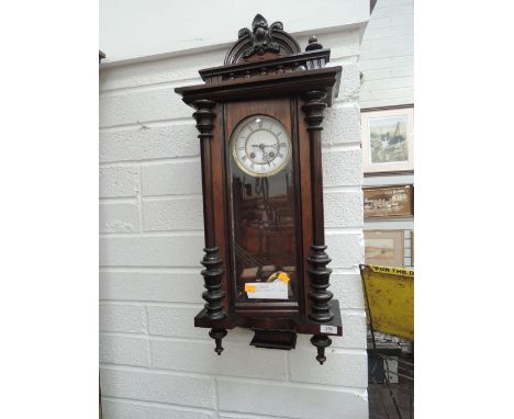 An early 20th century part mahogany Vienna style wall clock having arch and spindle crest or pillar glazed trunk