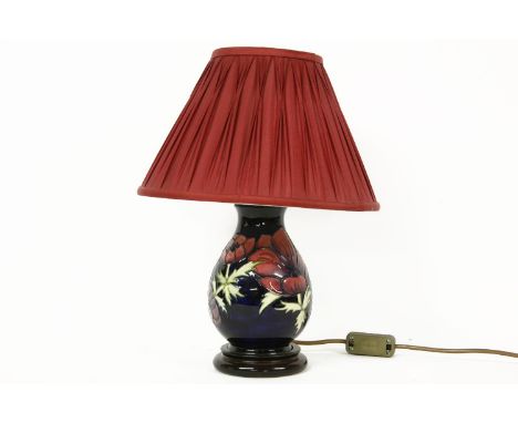 A Moorcraft table lamp, with a pleated red shade