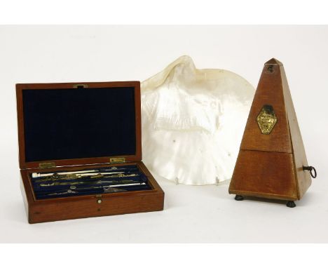 A mahogany cased geometry set, and a metronome, and a mother of pearl shell