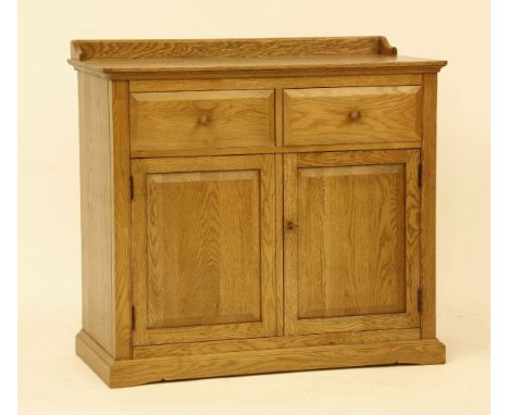 An Ercol oak dresser base/cupboard, two drawers over two door cupboard in medium oak finish, 97cm wide, 85cm high, 50cm deep