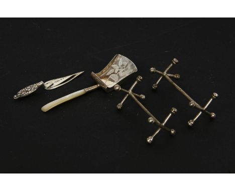 A Georgian silver caddy spoon, Birmingham 1810, a pair of Georgian knife rests, and a trowel bookmark