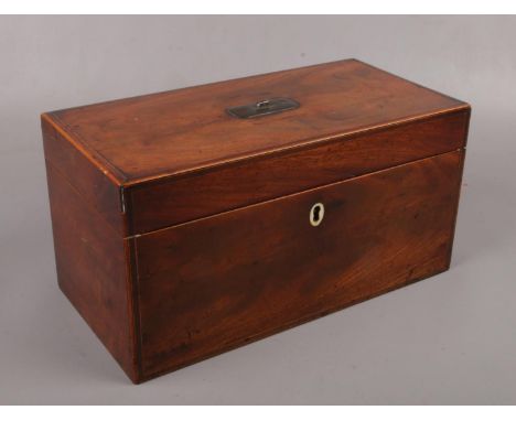 A Regency mahogany tea caddy with fitted interior.  Compartment lids with damage.