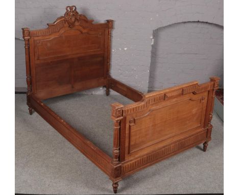 An ornate carved light oak French double bed frame.  