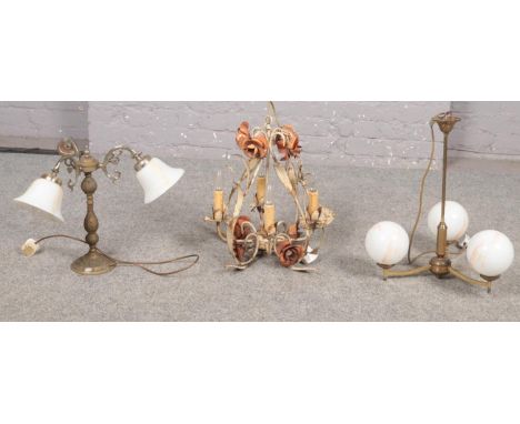 Three ceiling light fittings, a three arm brass with globed shades, ornate metal light with floral detail,  brass three arm u